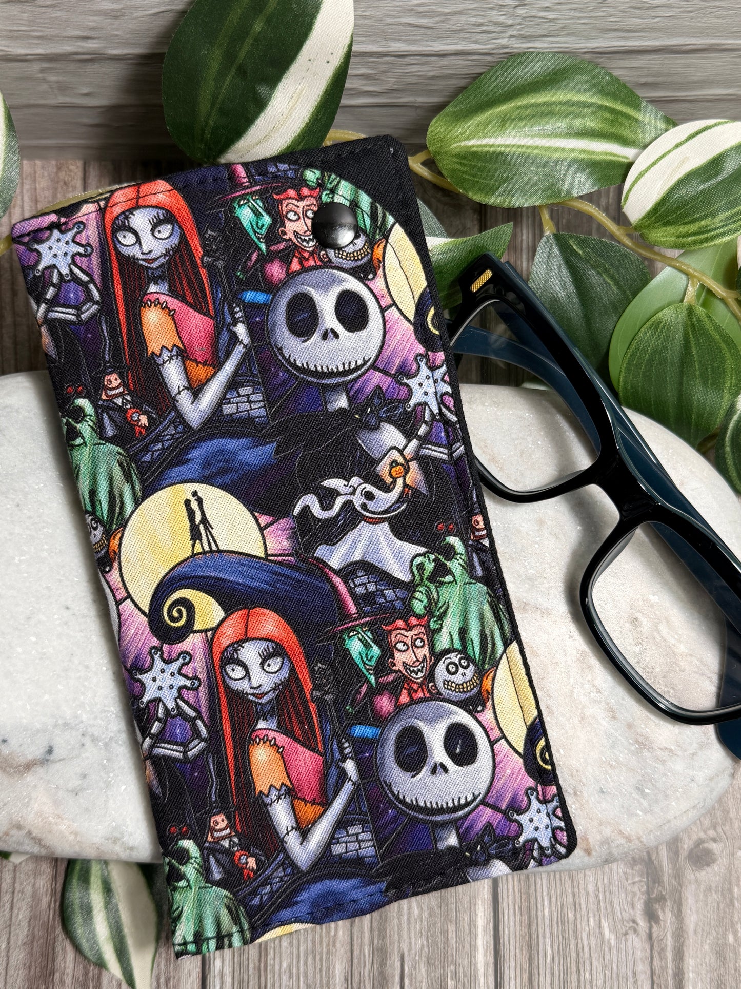 Glasses Case with Nightmare before Christmas characters on marble with glasses and leaves.