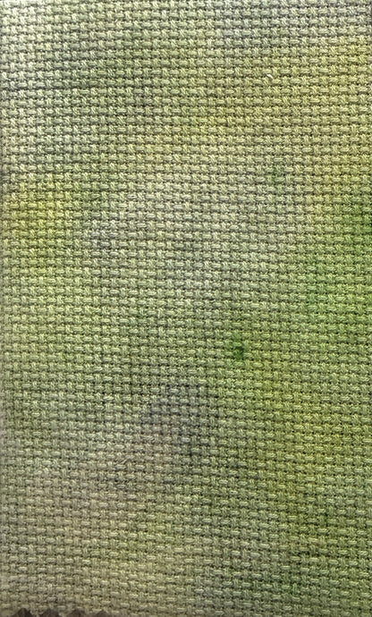 Close-up of a textured green cross stitch aida fabric surface