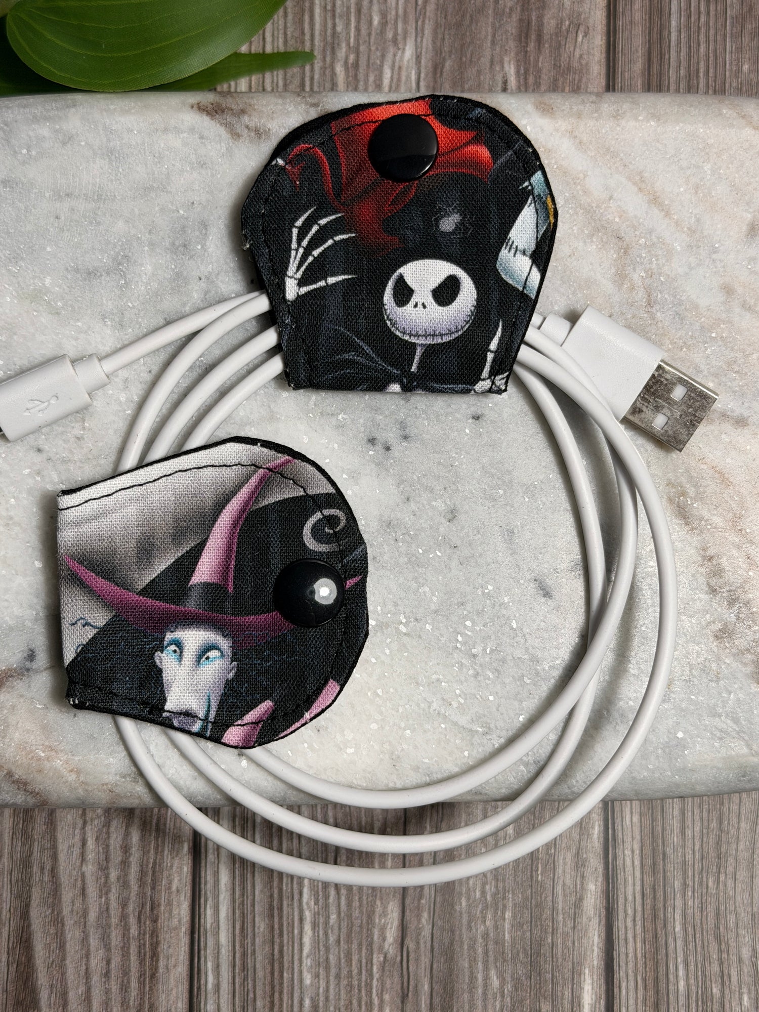 Jack skellington cable organiser with a mobile phone charger on a marble surface 