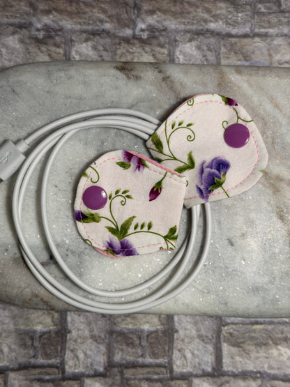 Floral cable organiser with a mobile phone charger on a marble surface 