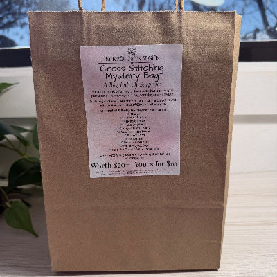 Brown paper bag with a mystery bag label on a light wooden surface