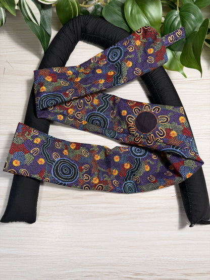 Indigenous print-patterned draught stopper cover sitting on a the draught stopper insert  against a wooden background
