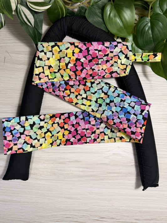 Colourful-patterned draught stopper cover sitting on a the draught stopper insert  against a wooden background
