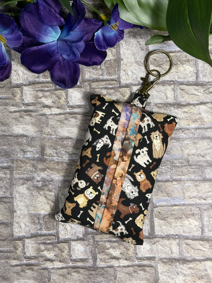 Fabric tissue pouch with a small dog  pattern on a keychain against a stone wall background
