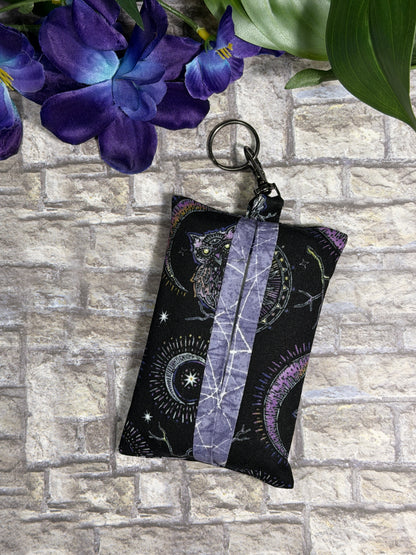 Fabric tissue pouch with a mystic pattern on a keychain against a stone wall background