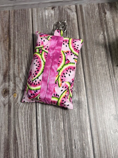 Pink fabric tissue pouch with watermelon pattern on a wooden surface