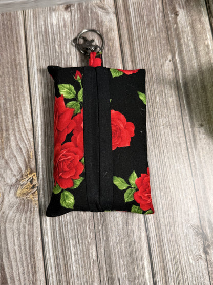 Black tissue pouch with red rose pattern on a wooden surface