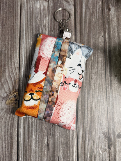 Keychain tissue holder pouch with cat-themed fabric on a wooden background