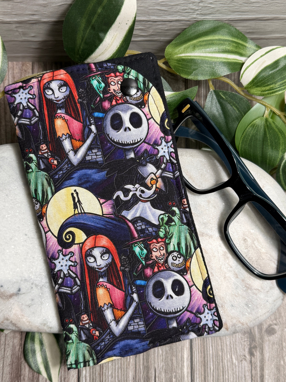 Glasses Case with Nightmare before Christmas characters on marble with glasses and leaves.
