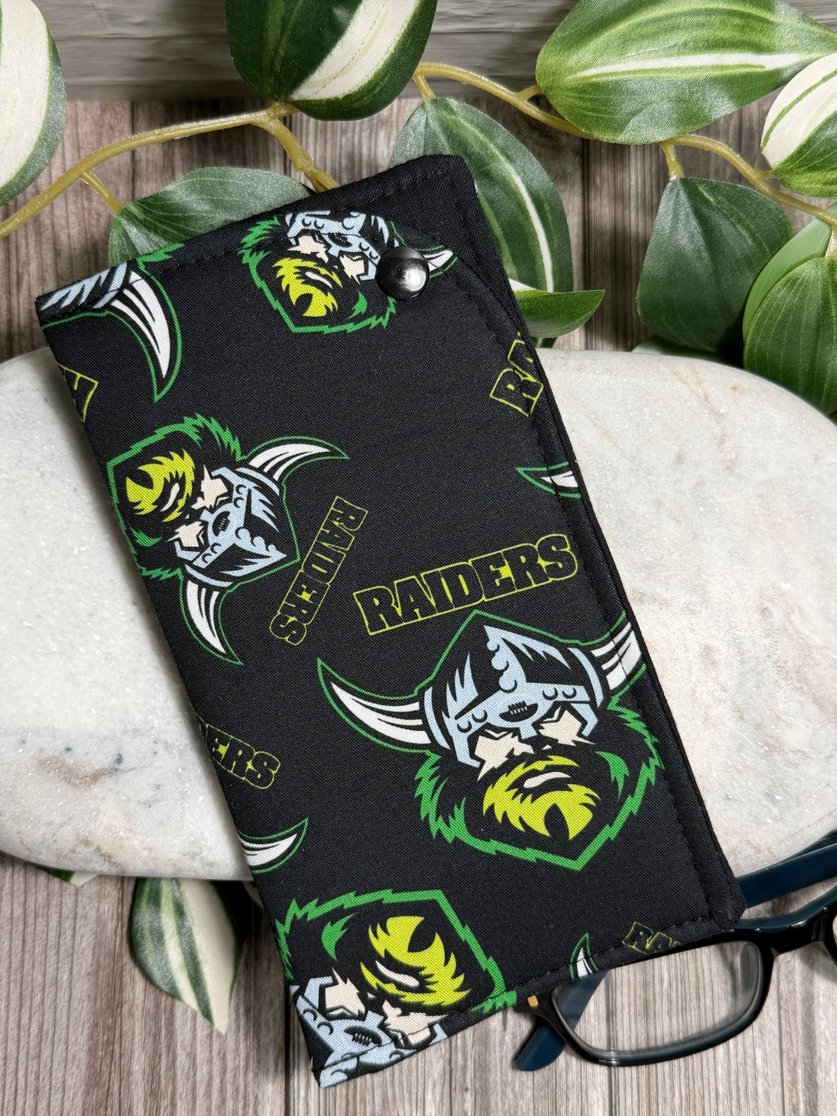 Glasses Case green and white designs on a stone surface with leaves in the background