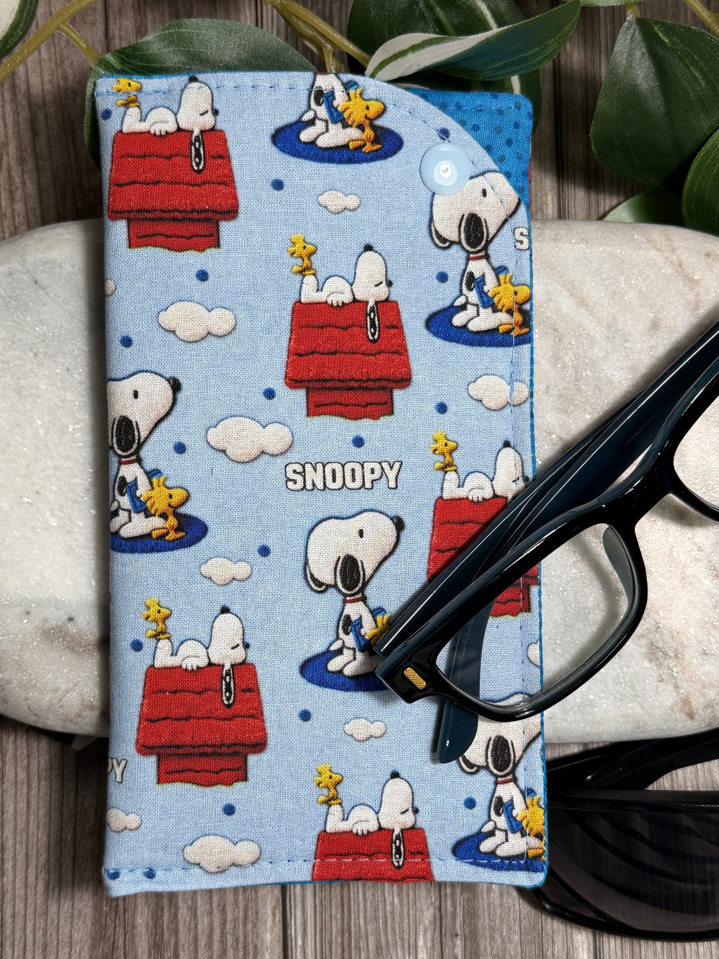 Glasses Case with a Snoopy-themed pattern with glasses on a wooden surface