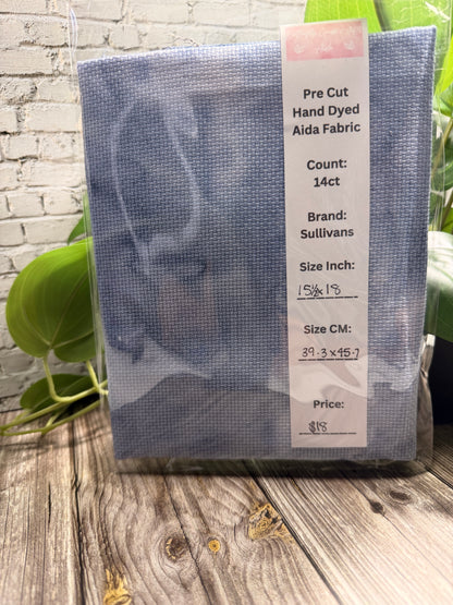 Pre-cut hand dyed cross stitch adia fabric with a label on a wooden surface