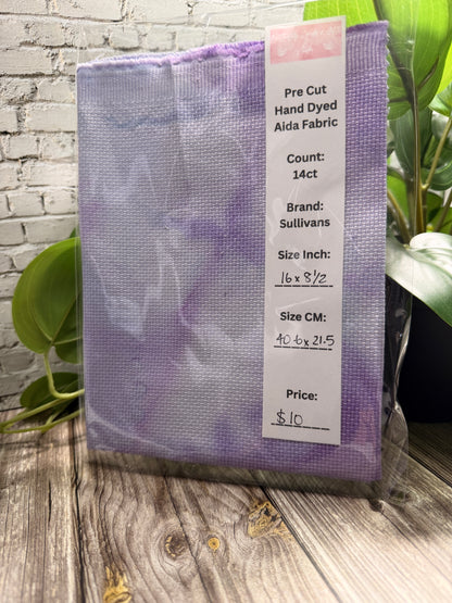 cross stitch adia purple fabric with a label on a wooden surface