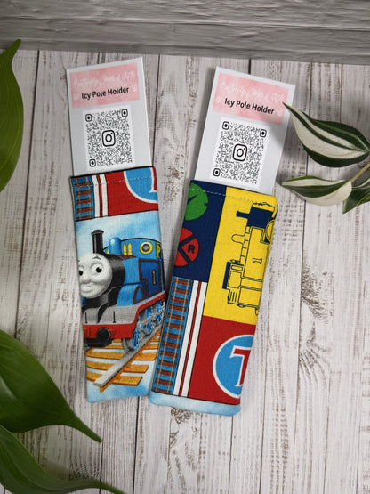 Fabric Icy Pole Holder with train designs on a wooden surface