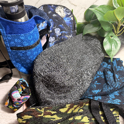 Collection of bags on a textured surface with a plant in the background