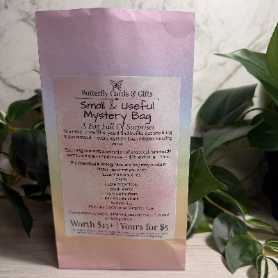 Mystery bag packaging with text on a light surface and plant background