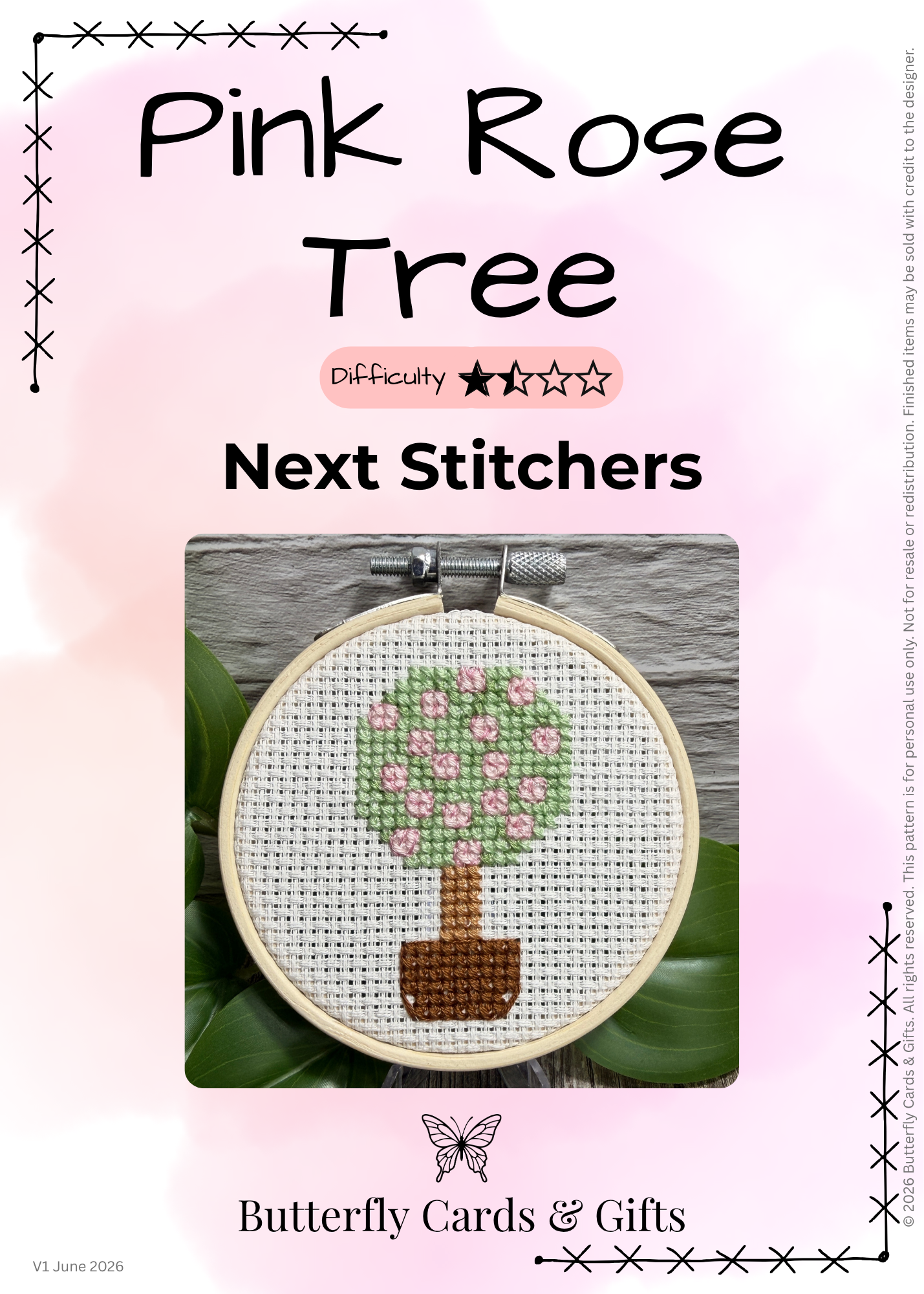 Promotional graphic for a cross-stitch pattern titled 'Pink Rose Tree' by Butterfly Cards & Gifts. The design shows a completed circular cross-stitch piece of a tree with pink flowers and a brown trunk on white fabric inside a hoop, centered on a soft pink background with decorative stitched borders and text.