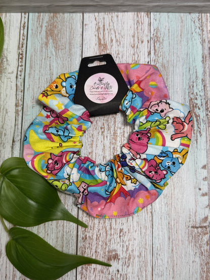 Colorful scrunchie with cartoon characters on a wooden surface with a plant leaf.