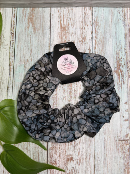 Scrunchie with a brand label on a wooden surface with leaves