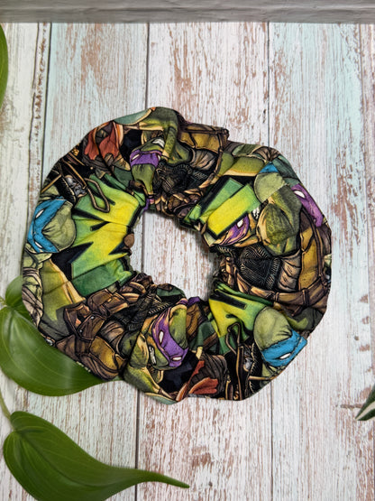 Colorful TMNT scrunchie on a wooden surface with leaves
