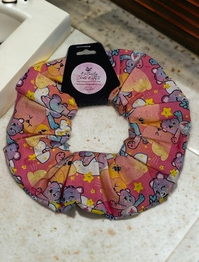 Pink scrunchie with cartoon  care bear designs on a countertop